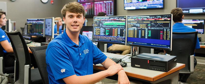 What is Economics and Finance Featured Image showing business student working in the MCOB lab sitting at computer.