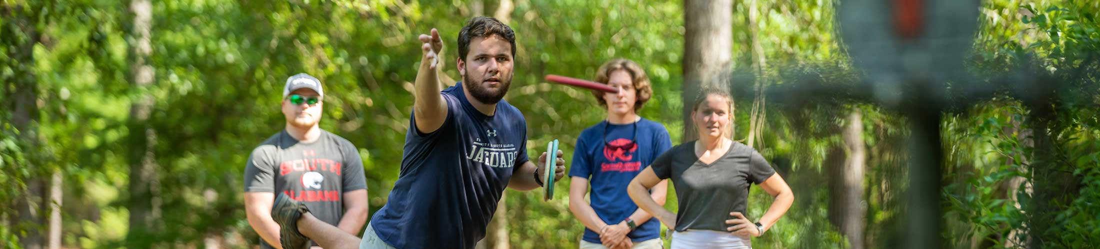 Students playing disc golf on campus.