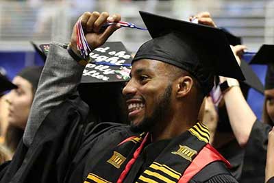 Male smiling and holding tassle at graduation